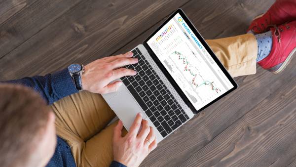 A man sitting on the floor with an opened trading platform in laptop